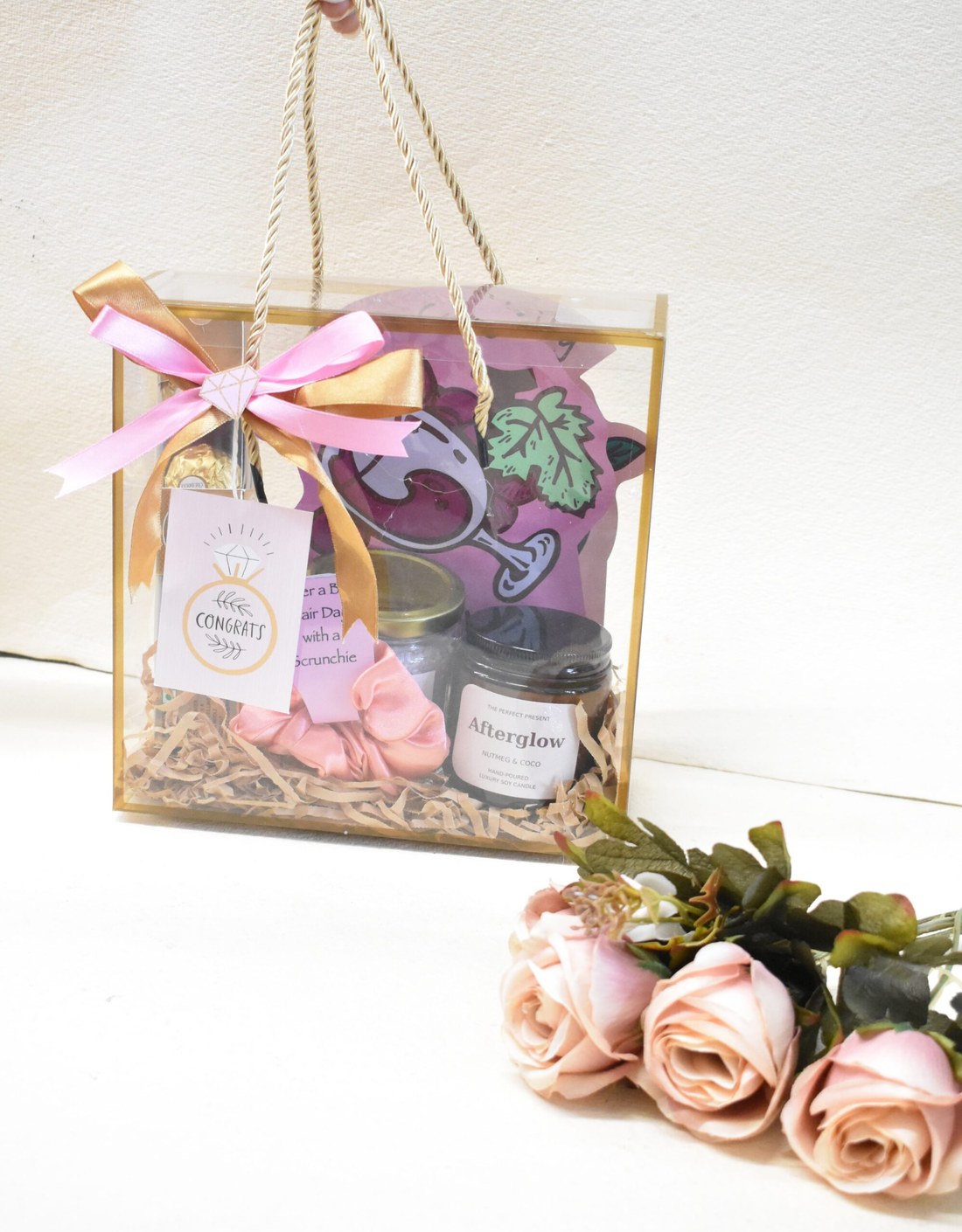 Transparent gift bag with gold rope handles and congrats tag