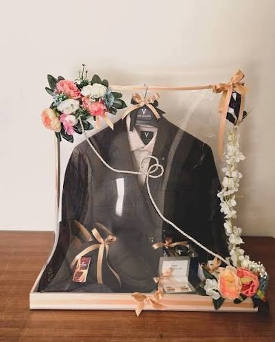 Groom suit packed in a clear frame with flowers