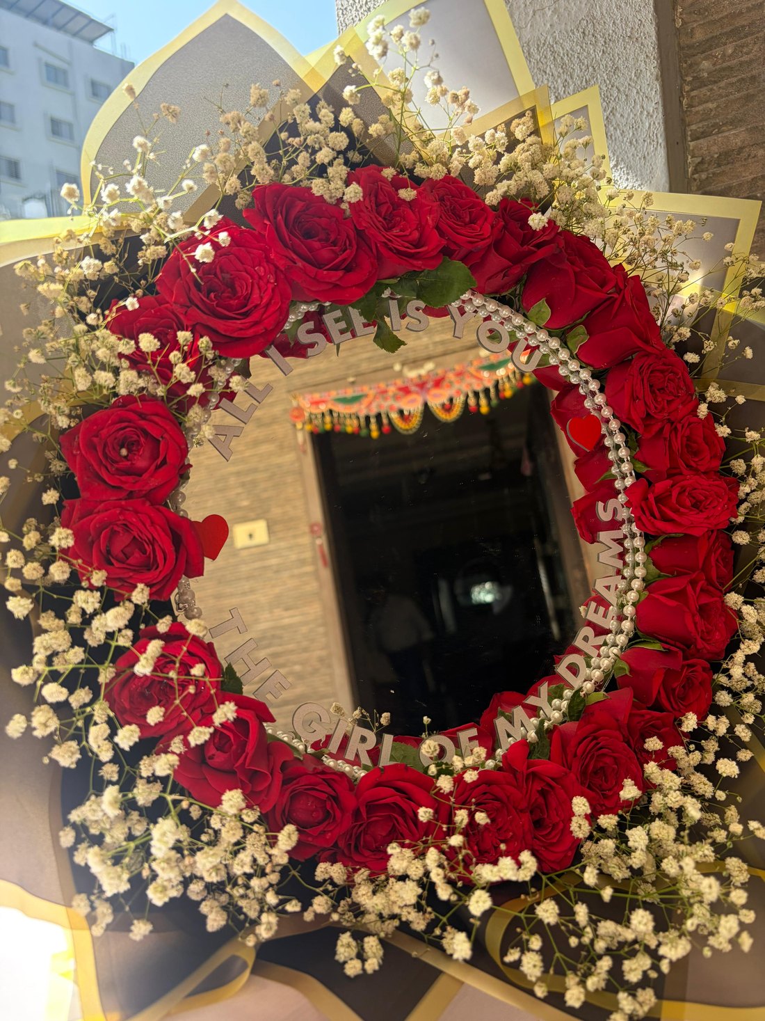 Mirror framed with red roses and gypsophila