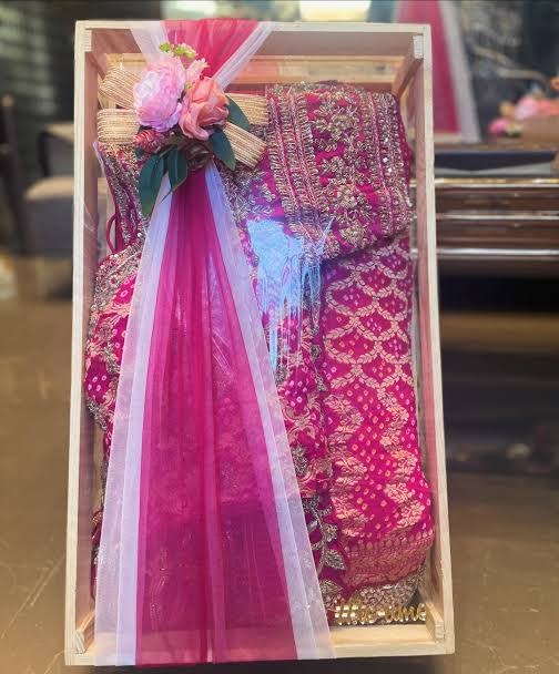 Magenta saree packing in a wooden crate